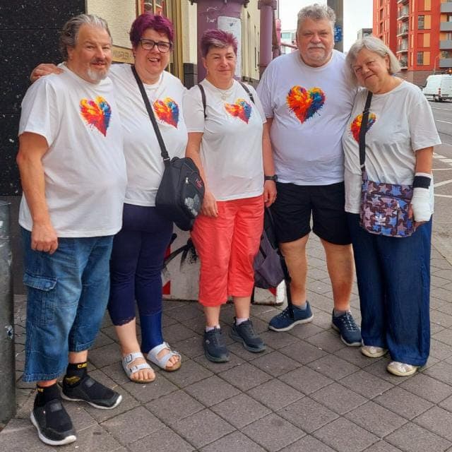 Das Team der Sozialen Herzen — fünf Personen in weißen Shirts mit dem bunten Herz-Logo