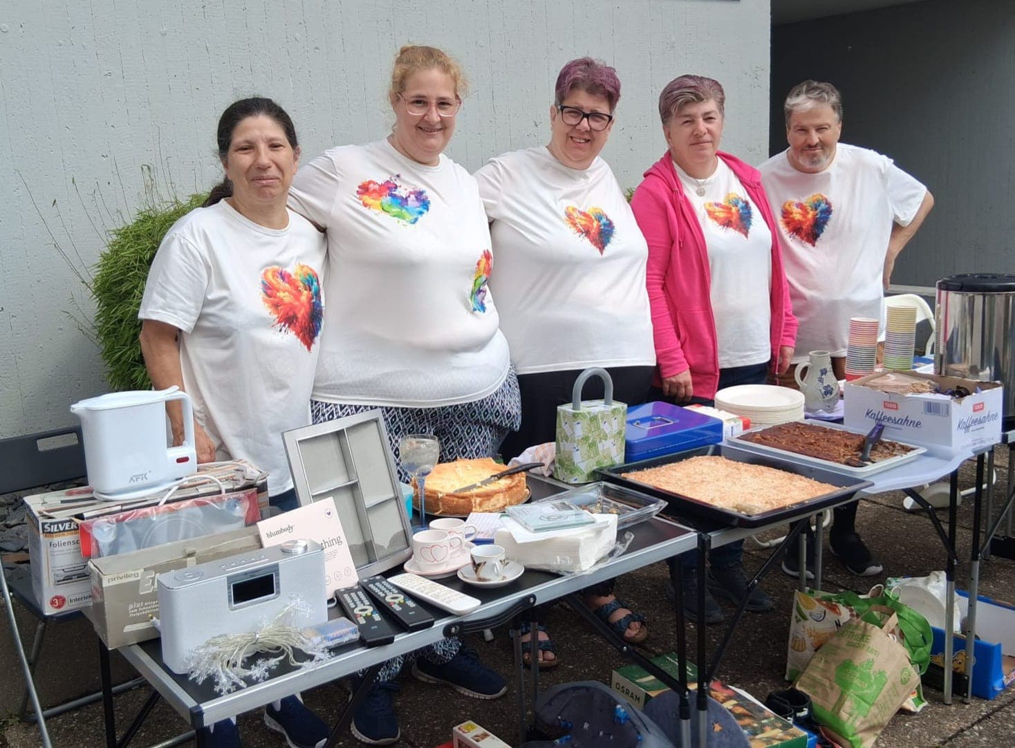 Die Sozialen Herzen am Verkaufstisch beim Hofflohmarkt mit Kuchen und selbstgemachten Dingen